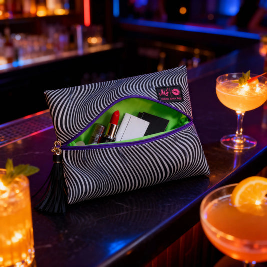 Striped makeup bag with cosmetics on a bar counter with cocktails
