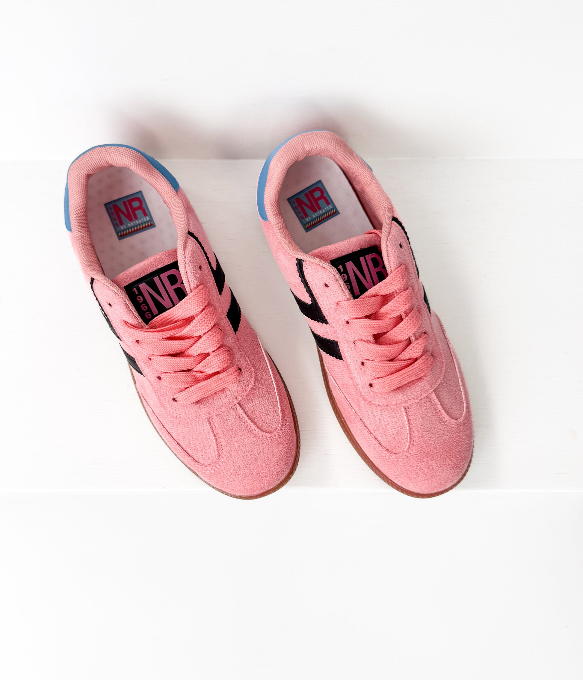 Pair of pink sneakers with black accents on a white background