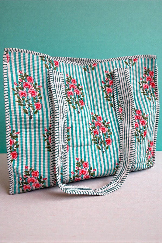 Two floral-patterned bags with striped design on a teal background