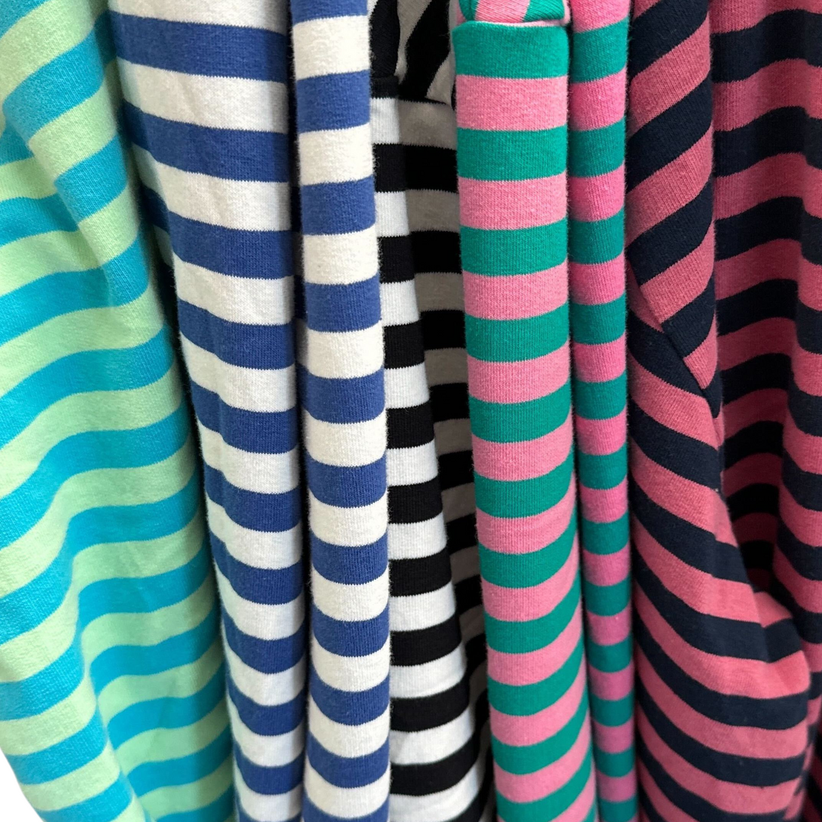 a photo of five different striped pullovers